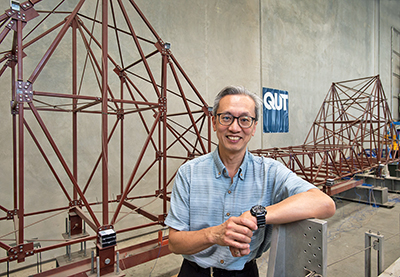 QUT professor Tommy Chan with a model of Brisbane's Story Bridge used to simulate bridge vibrations and research sensing systems.