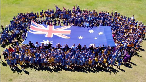 The giant Australian Parliament House (APH) flag is unfurled at Jindalee State School, Brisbane, as the APH flag educational tour across Australian schools begins. Image: APH.