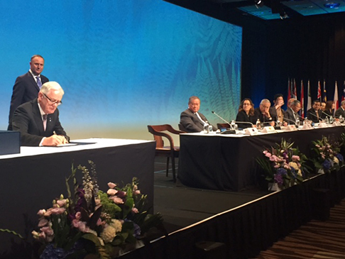 Andrew Robb (left) signs the Trans Pacific Partnership (TPP) agreement.